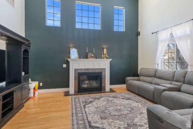 5964 W Jackling Way, West Jordan, UT 84081 - living area featuring a tiled fireplace, visible vents, light wood-type flooring, and baseboards