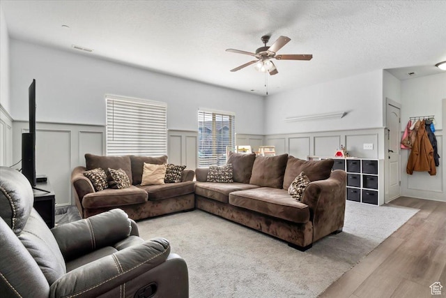 3635 E Clear Rock Rd Unit 4, Eagle Mountain, UT 84005 - living room with a ceiling fan, a wainscoted wall, visible vents, light wood-style floors, and a textured ceiling