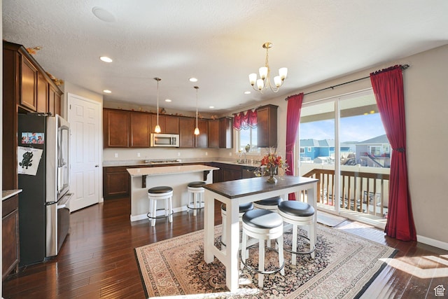 kitchen featuring a center island, dark wood-style flooring, a breakfast bar area, and stainless steel appliances
