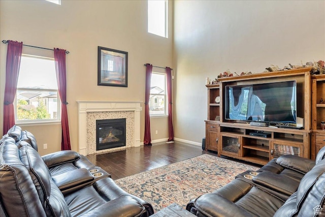 5663 W Yukon Park Ln S, Herriman, UT 84096 - living room with wood finished floors, healthy amount of natural light, a glass covered fireplace, baseboards, and a towering ceiling