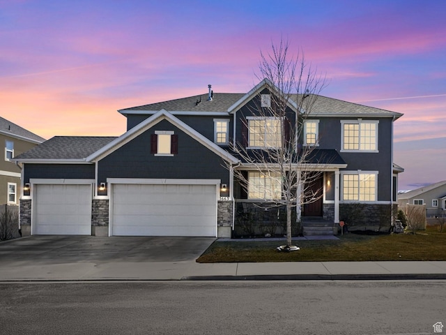 view of front of home featuring a yard, an attached garage, stone siding, and driveway