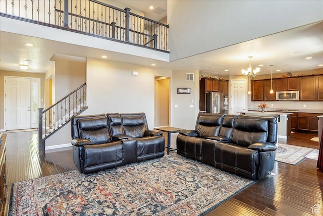 5663 W Yukon Park Ln S, Herriman, UT 84096 - living room with dark wood finished floors, a chandelier, stairway, baseboards, and a towering ceiling