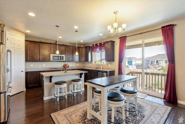 5663 W Yukon Park Ln S, Herriman, UT 84096 - kitchen featuring stainless steel appliances, a center island, a chandelier, a sink, and dark wood-style flooring