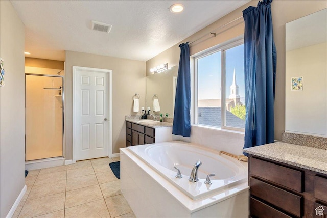 5663 W Yukon Park Ln S, Herriman, UT 84096 - bathroom with vanity, a garden tub, a stall shower, tile patterned flooring, and baseboards