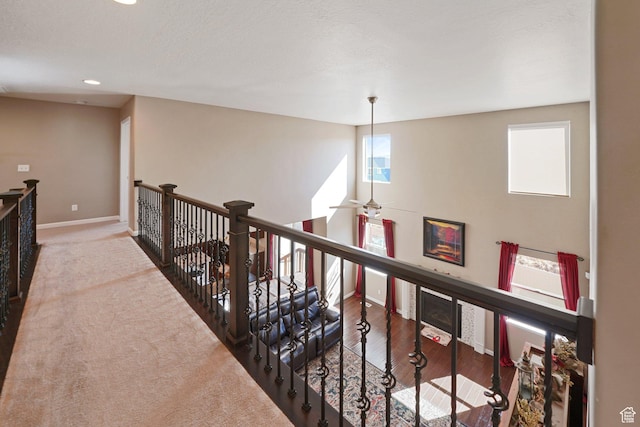 hallway featuring recessed lighting, an upstairs landing, and baseboards