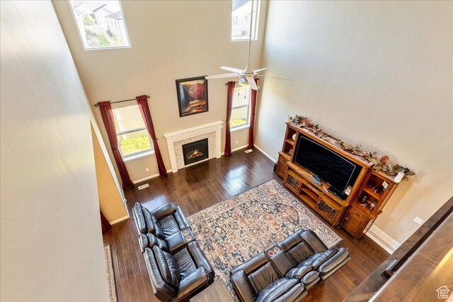 5663 W Yukon Park Ln S, Herriman, UT 84096 - living room with baseboards, a towering ceiling, wood finished floors, a glass covered fireplace, and a ceiling fan