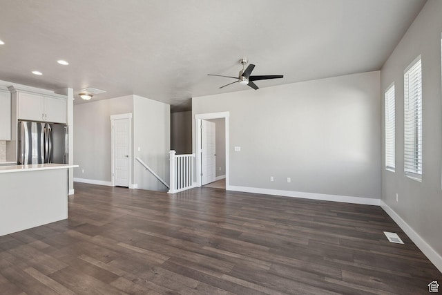 1722 W Shade Ln, Riverton, UT 84065 - unfurnished living room with a ceiling fan, visible vents, dark wood-style flooring, and baseboards