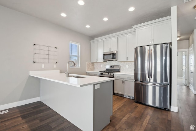 1722 W Shade Ln, Riverton, UT 84065 - kitchen featuring backsplash, appliances with stainless steel finishes, a peninsula, dark wood-style floors, and a sink