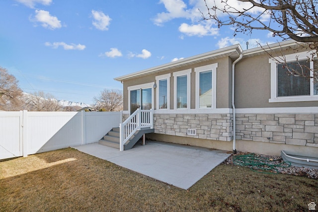 1722 W Shade Ln, Riverton, UT 84065 - back of house featuring stucco siding, stone siding, a patio, fence, and a yard