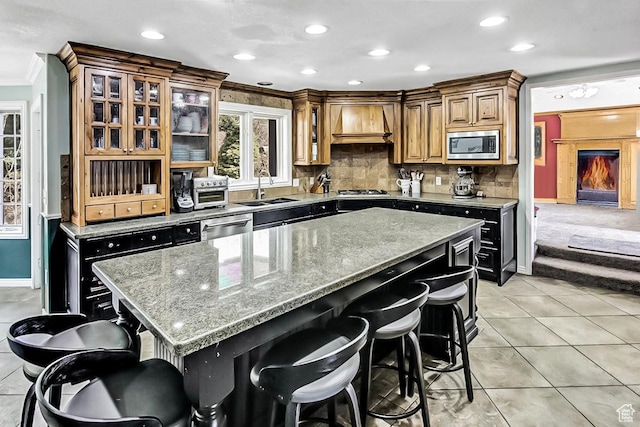 6464 Bybee Dr, Ogden, UT 84403 - kitchen featuring premium range hood, a sink, stainless steel appliances, crown molding, and a kitchen breakfast bar
