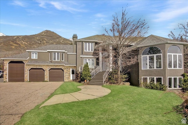 6464 Bybee Dr, Ogden, UT 84403 - view of front of house with a front yard, driveway, a chimney, stucco siding, and stone siding
