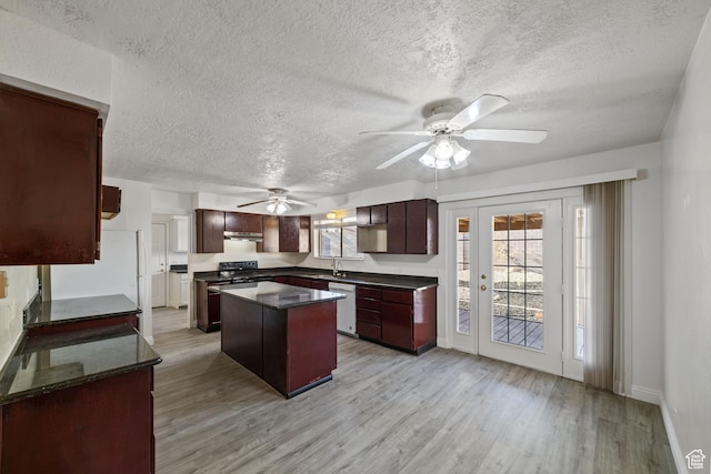 kitchen featuring a sink, light wood-type flooring, a kitchen island, and white dishwasher