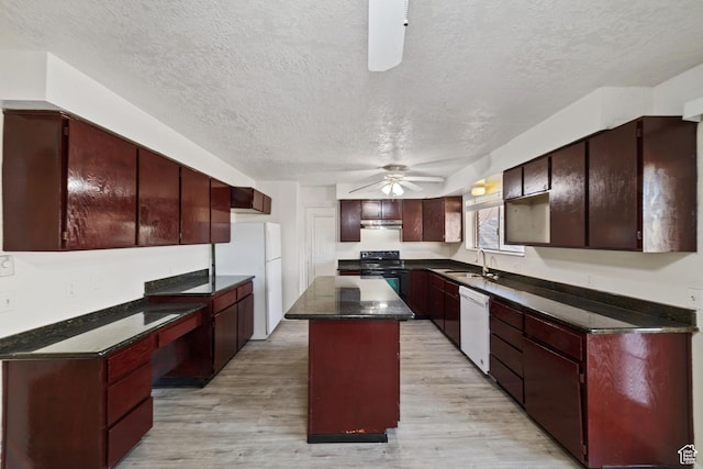 kitchen with white appliances, a ceiling fan, light wood-style flooring, a sink, and a center island