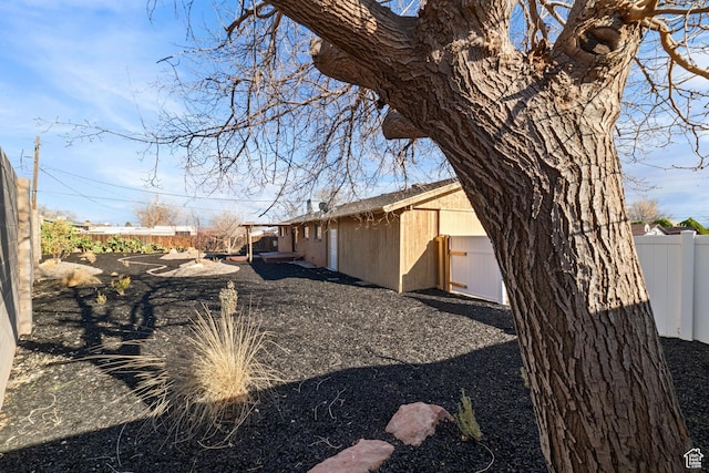 view of side of property featuring an outdoor structure and fence