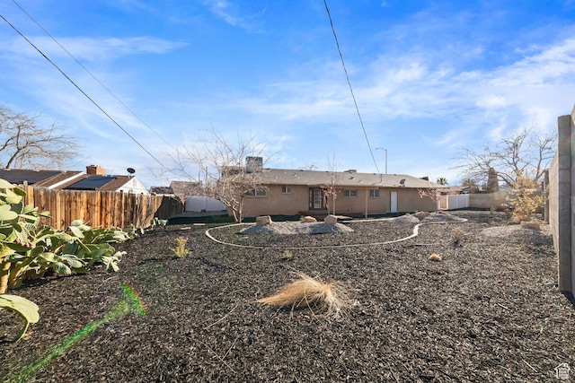 rear view of house featuring a fenced backyard