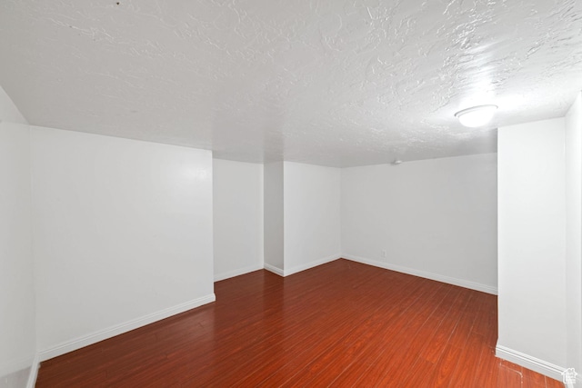 interior space featuring a textured ceiling, baseboards, and wood finished floors