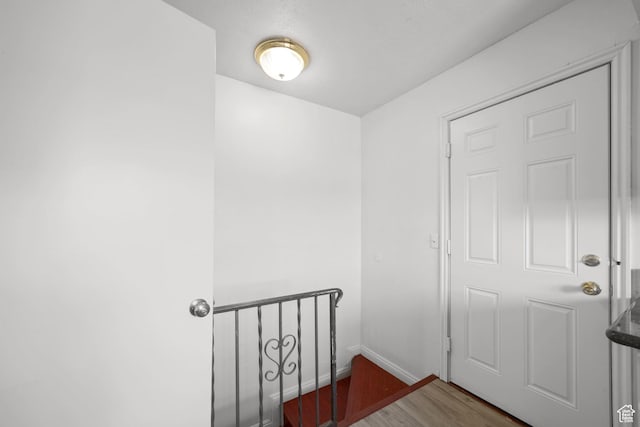 stairway featuring baseboards and wood finished floors