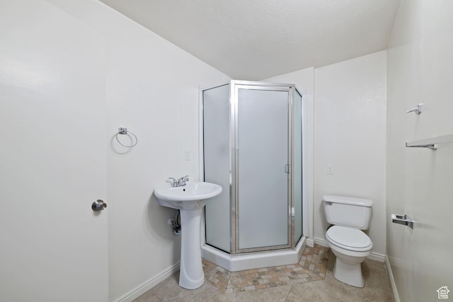 full bath featuring baseboards, toilet, and a stall shower