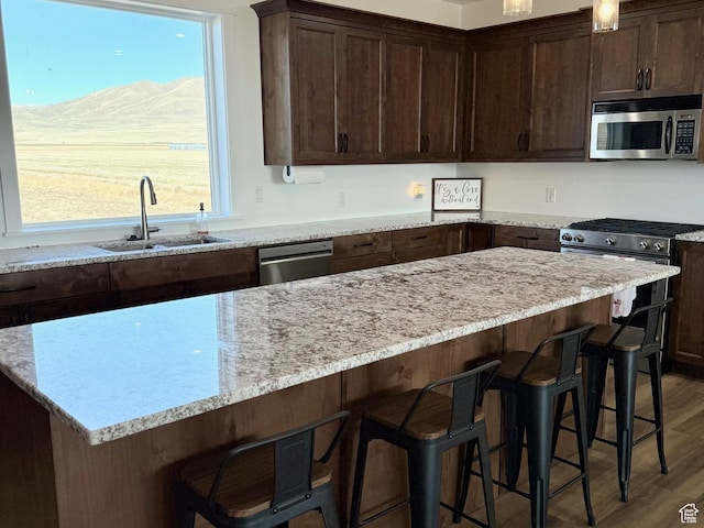 13342 N 10800 W Unit 7, Tremonton, UT 84337 - kitchen with a sink, light stone countertops, dark brown cabinets, appliances with stainless steel finishes, and wood finished floors