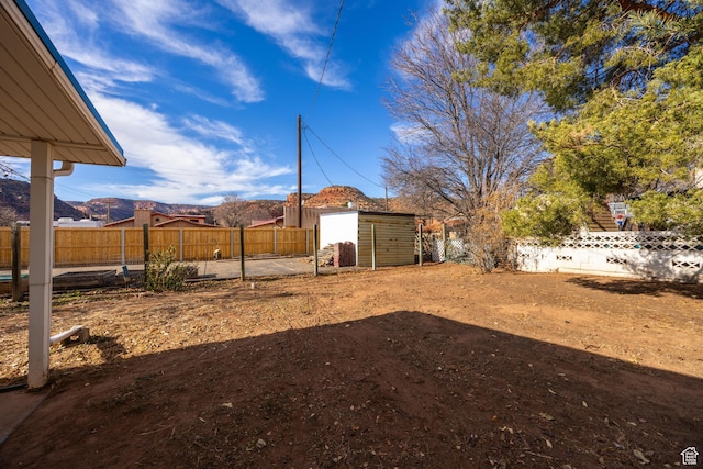 311 N 300 W, Kanab, UT 84741 - view of yard featuring a fenced backyard, an outdoor structure, a storage unit, and a mountain view
