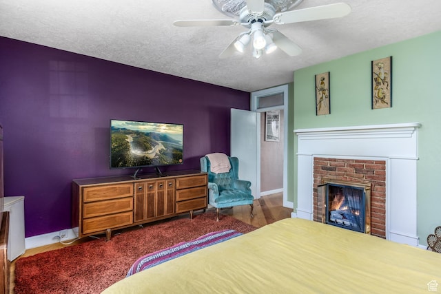 311 N 300 W, Kanab, UT 84741 - bedroom with a ceiling fan, wood finished floors, a textured ceiling, and a fireplace