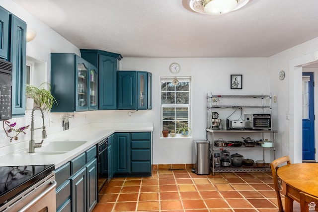 311 N 300 W, Kanab, UT 84741 - kitchen featuring a sink, glass insert cabinets, blue cabinetry, light countertops, and black appliances