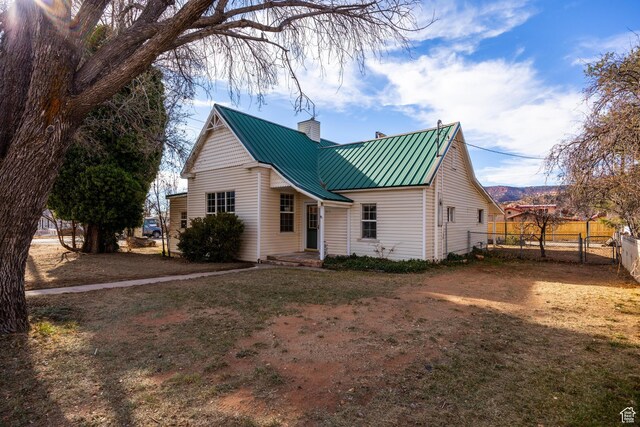 311 N 300 W, Kanab, UT 84741 - view of front of house with fence, a chimney, and metal roof