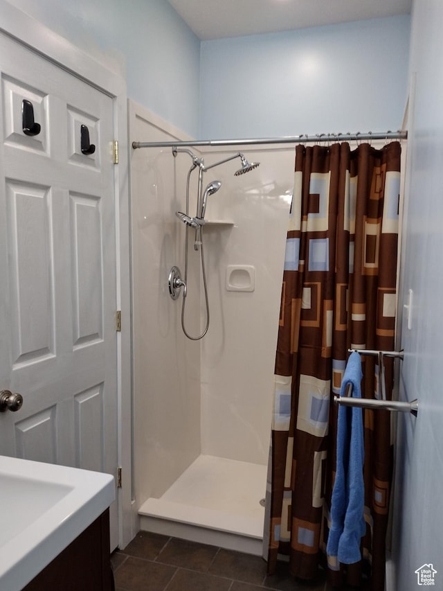 full bathroom with vanity, tile patterned floors, and a shower stall
