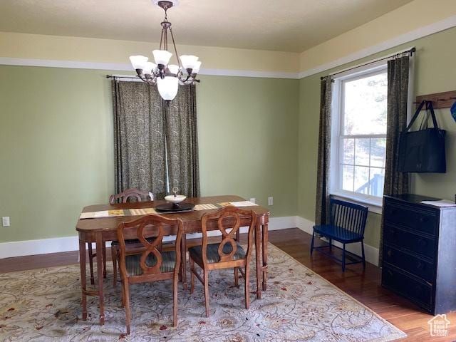 dining room with an inviting chandelier, baseboards, and wood finished floors
