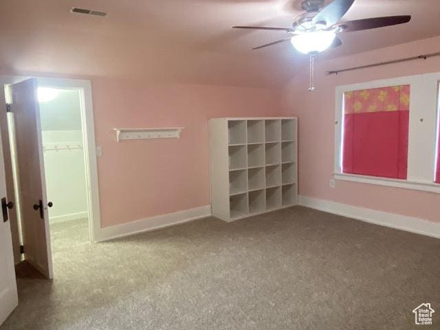 carpeted spare room featuring baseboards, visible vents, and a ceiling fan
