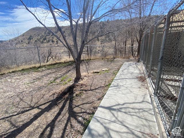 view of yard with a mountain view and fence