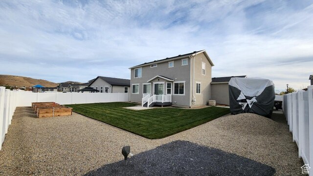 1395 E Kelsey Dr, Eagle Mountain, UT 84005 - rear view of house with a lawn, stucco siding, a fenced backyard, and a garden