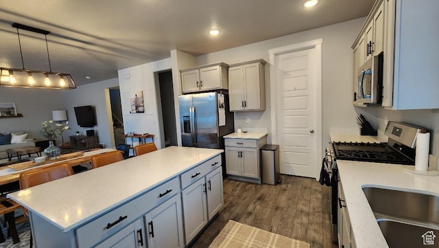1395 E Kelsey Dr, Eagle Mountain, UT 84005 - kitchen featuring light countertops, stainless steel appliances, a center island, a sink, and dark wood-style floors