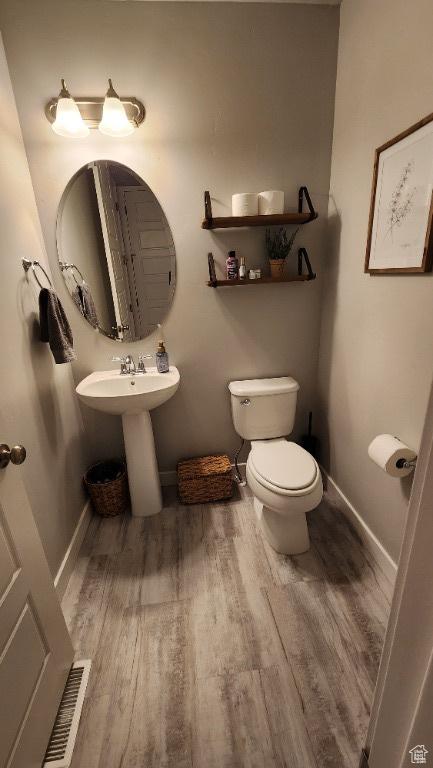 1395 E Kelsey Dr, Eagle Mountain, UT 84005 - bathroom with toilet, visible vents, baseboards, and wood finished floors