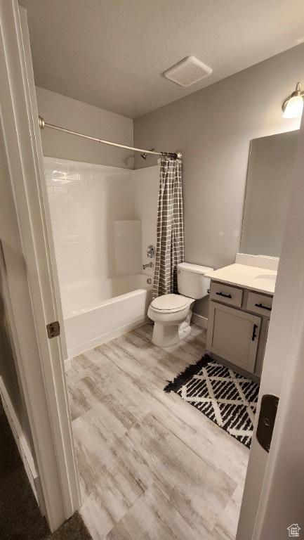 1395 E Kelsey Dr, Eagle Mountain, UT 84005 - bathroom featuring toilet, vanity, wood finished floors, visible vents, and shower / bath combination with curtain