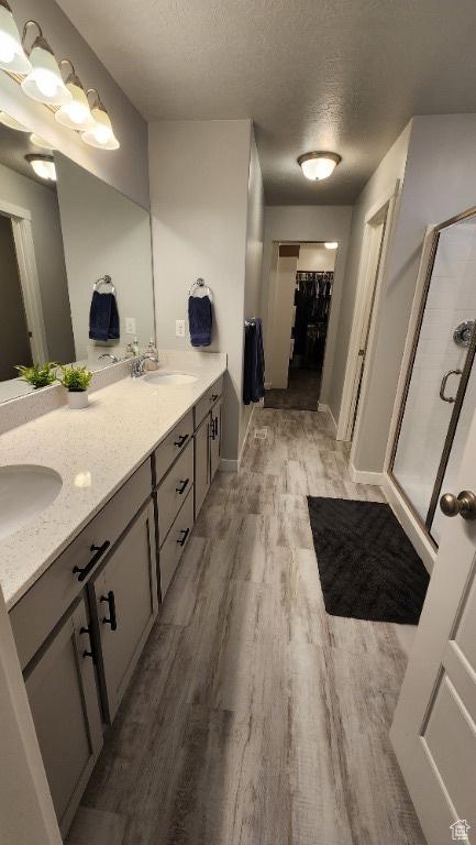 1395 E Kelsey Dr, Eagle Mountain, UT 84005 - full bath featuring a textured ceiling, a sink, a shower stall, and wood finished floors