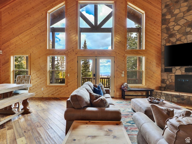 161 N Irish Trl, Brian Head, UT 84719 - living room with hardwood / wood-style flooring, french doors, wooden walls, a stone fireplace, and a towering ceiling