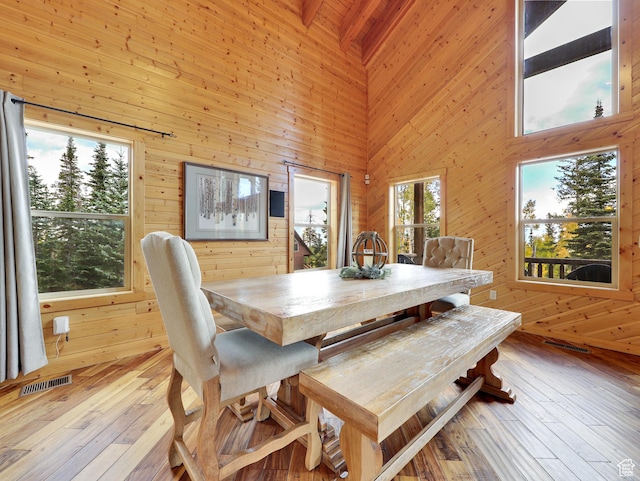 161 N Irish Trl, Brian Head, UT 84719 - dining space with hardwood / wood-style floors, wooden walls, visible vents, a towering ceiling, and beamed ceiling