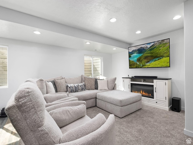 6119 N White Rock Rd, Eagle Mountain, UT 84005 - carpeted living room featuring recessed lighting, a textured ceiling, and a glass covered fireplace