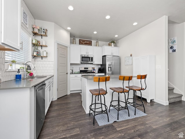 6119 N White Rock Rd, Eagle Mountain, UT 84005 - kitchen with a sink, a kitchen island, white cabinetry, stainless steel appliances, and a breakfast bar area
