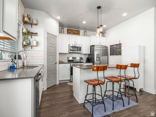 6119 N White Rock Rd, Eagle Mountain, UT 84005 - kitchen featuring stainless steel appliances, a breakfast bar area, decorative backsplash, dark countertops, and dark wood-style flooring