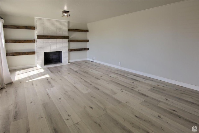 454 E 3100 N, North Ogden, UT 84414 - unfurnished living room with a large fireplace, light wood-type flooring, and baseboards