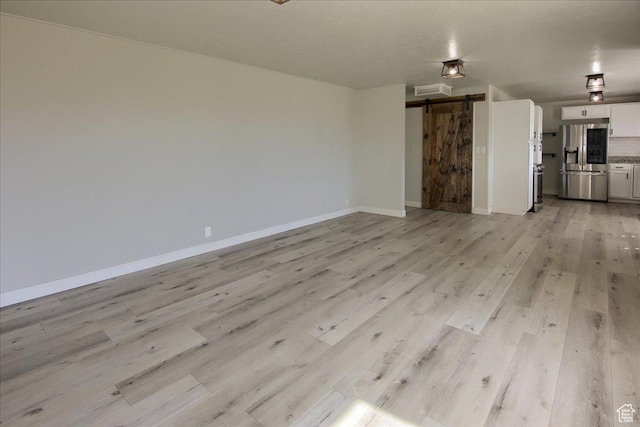 454 E 3100 N, North Ogden, UT 84414 - unfurnished living room with light wood-type flooring, a barn door, and baseboards