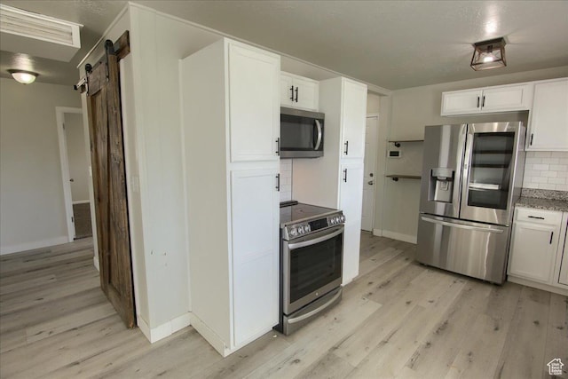 454 E 3100 N, North Ogden, UT 84414 - kitchen featuring a barn door, light wood-type flooring, tasteful backsplash, and stainless steel appliances
