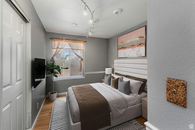 4201 S 2260 W, Taylorsville, UT 84129 - bedroom featuring rail lighting, baseboards, and wood finished floors