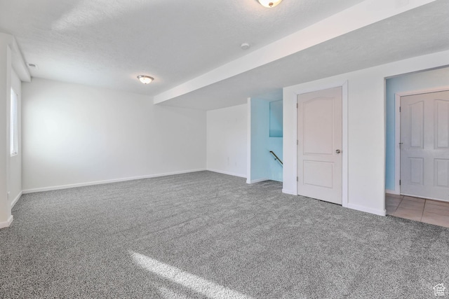 interior space featuring baseboards, carpet floors, and a textured ceiling