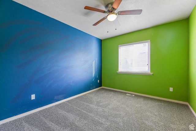 unfurnished room featuring carpet flooring, baseboards, visible vents, and ceiling fan
