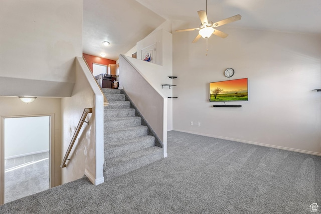 stairway with a ceiling fan, baseboards, carpet floors, and high vaulted ceiling