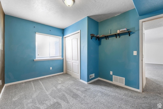 unfurnished bedroom featuring carpet, visible vents, a closet, and baseboards