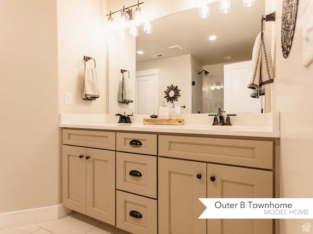 full bath with tiled shower, double vanity, a sink, baseboards, and visible vents
